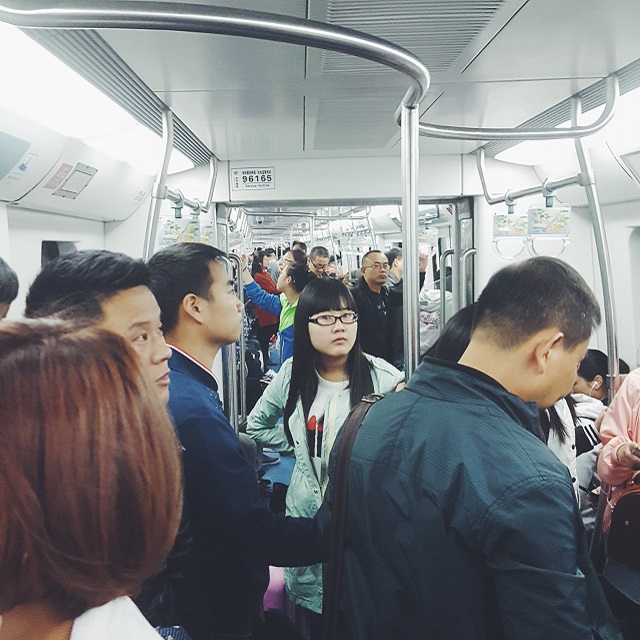 Pekinger U-Bahn von innen mit vielen Fahrgästen