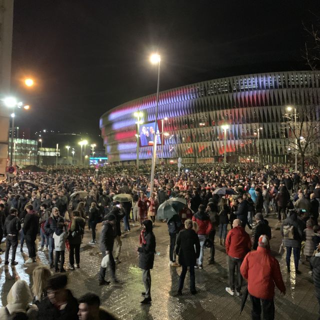 Menschenmasse bei Nacht vor einem Fußballstadion