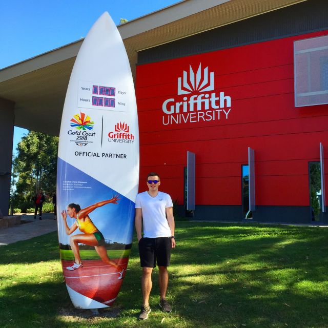 Dominik vor einem Schild der Griffith University