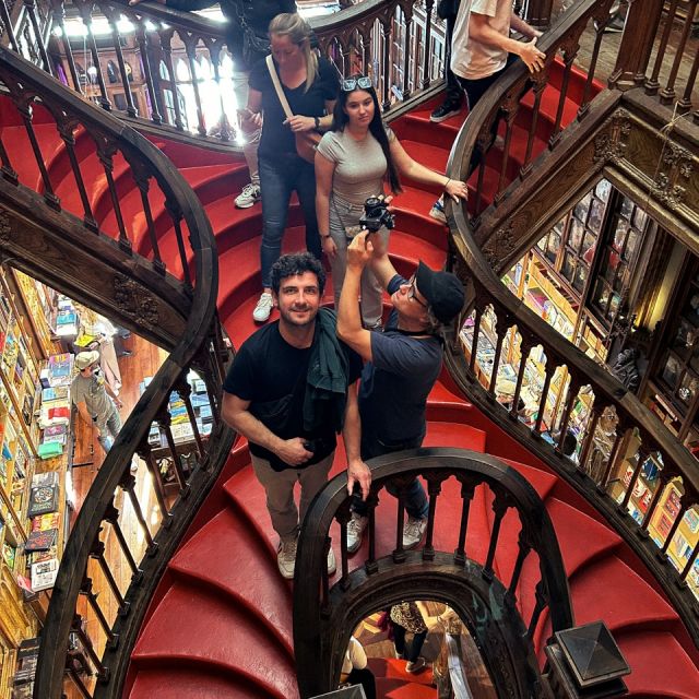 Zwei Männer in der Livraria Lello in Porto, einer hält eine Kamera zur Decke gerichtet