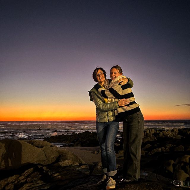 Zwei Frauen auf einem Felsen vor dem Meer