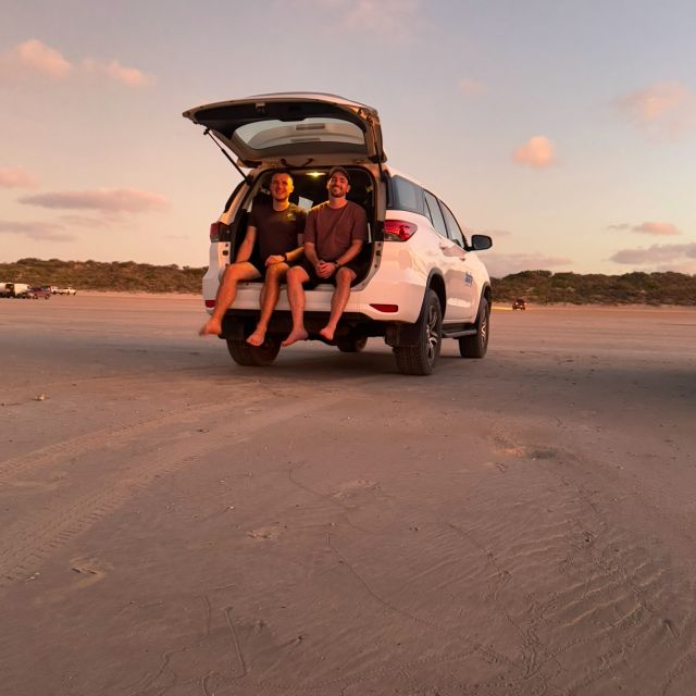 Sonnenuntergang aus Kofferraum sitzend am Strand