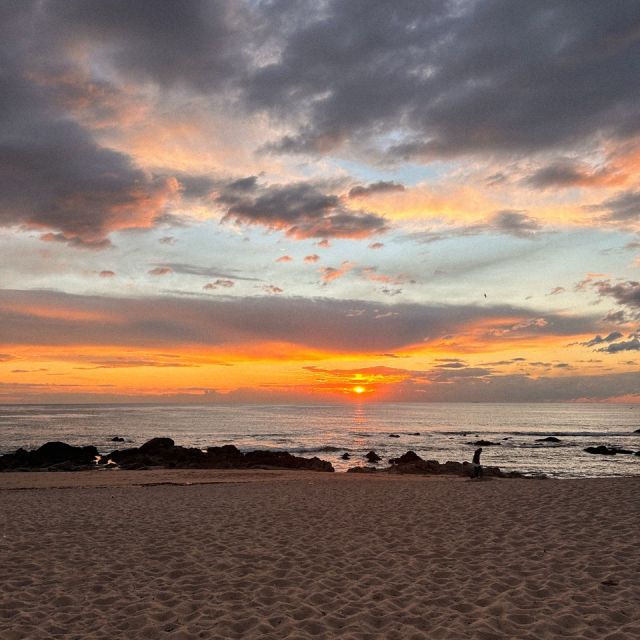 Sonnenuntergang am Strand, bewölkt, roter Himmel.