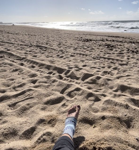 Ein verletzter Fuß und ein Meer im Hintergrund.